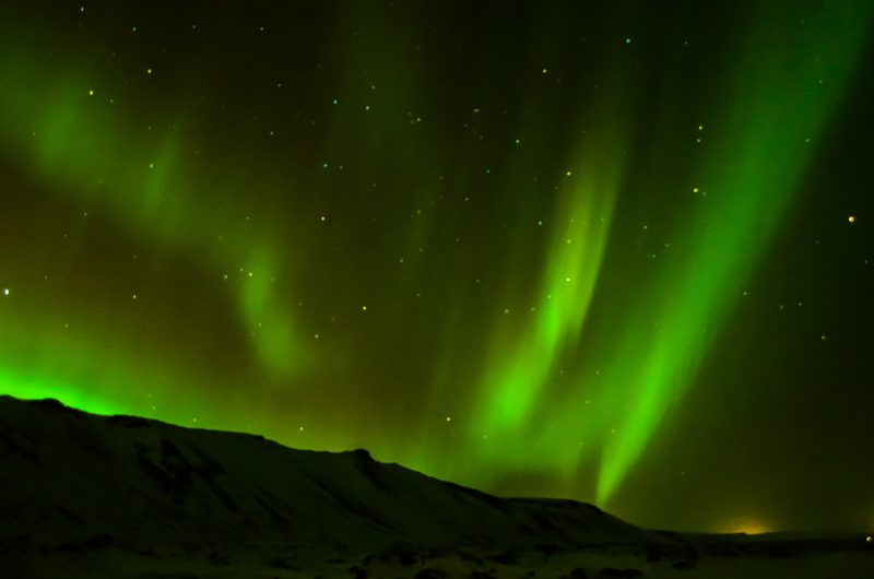 Polarlicht über verschneiten Bergen in Island
